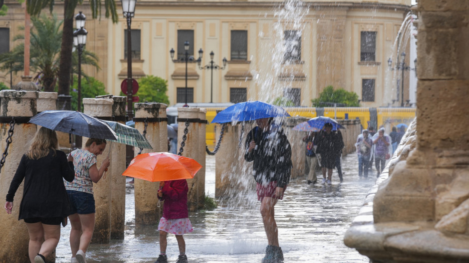 Transeúntes protegidos con paraguas de la lluvia en Sevilla