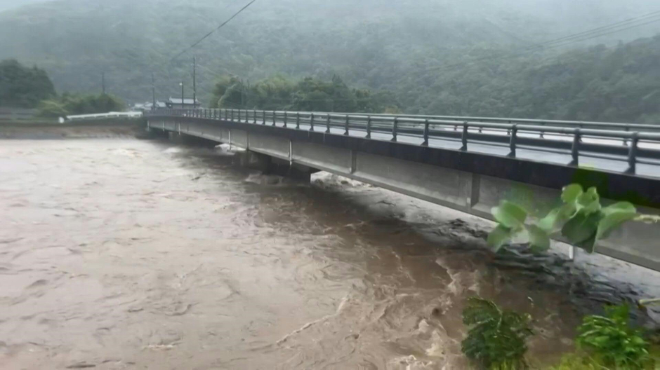 El caudal de un río del sur de Japón alcanza prácticamente la carretera que pasa sobre un puente