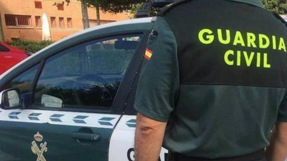 Imagen de archivo de un agente de la Guardia Civil ante un coche patrulla