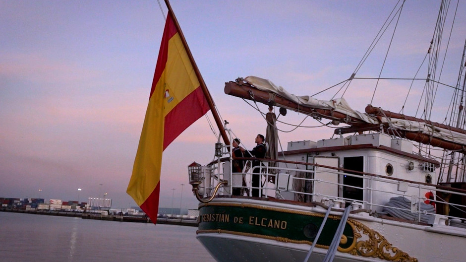 Arriado de la bandera de España al atardecer en Elcano