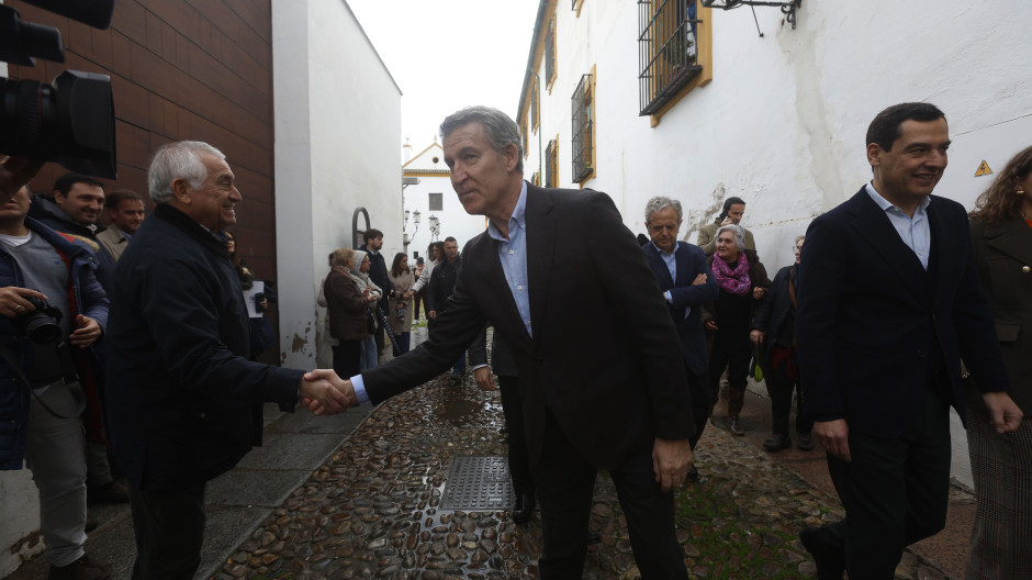 El presidente del PP, Alberto Núñez Feijóo (c), saluda a un hombre que se ha acercado en la calle de camino a la residencia de Mayores Fundación Hospital San Jacinto y Nuestra Señora de los Dolores en Córdoba