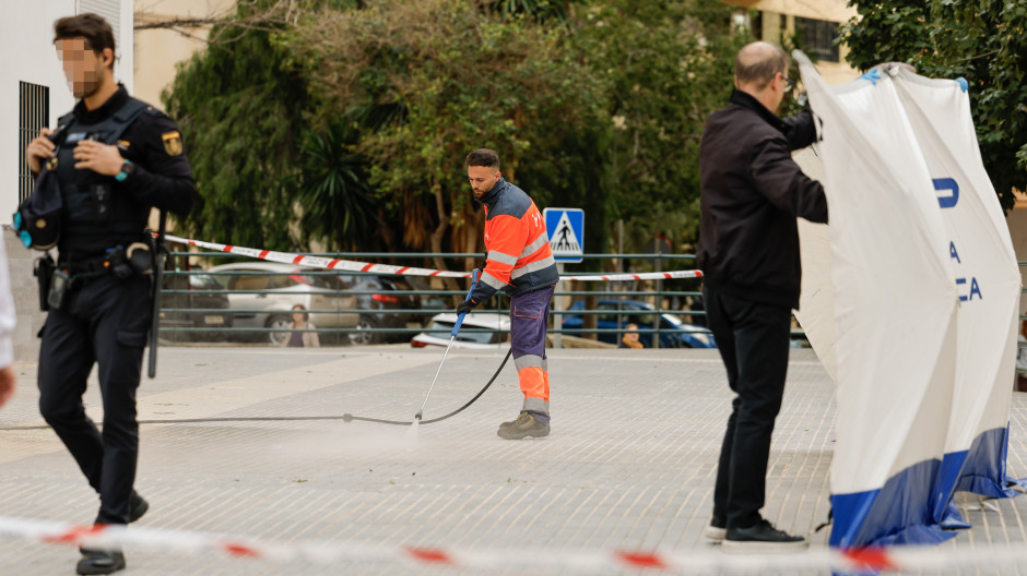 Un trabajador del Ayuntamiento de Málaga baldea la zona donde un hombre y una mujer han fallecido tras precipitarse este martes al vacío