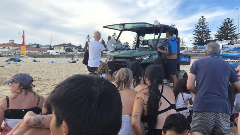 Un grupo de bañistas observa la escena de la detención de lso tiradores en la playa de Bondie (Australia)
