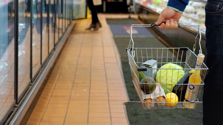 Gente comprando en un supermercado con la cesta de la compra