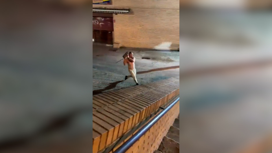 Un hombre descamisado lanza un adoquín a varios agentes de Policía la madrugada de este domingo en Leganés