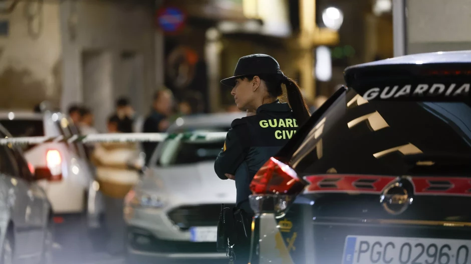 Imagen de una agente de la Guardia Civil junto a la casa en la que se produjo el doble crimen