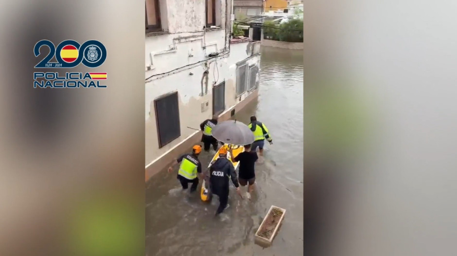 Imagen del rescate de la Policía a una anciana de 93 años en Gandía con una tabla de pádel surf