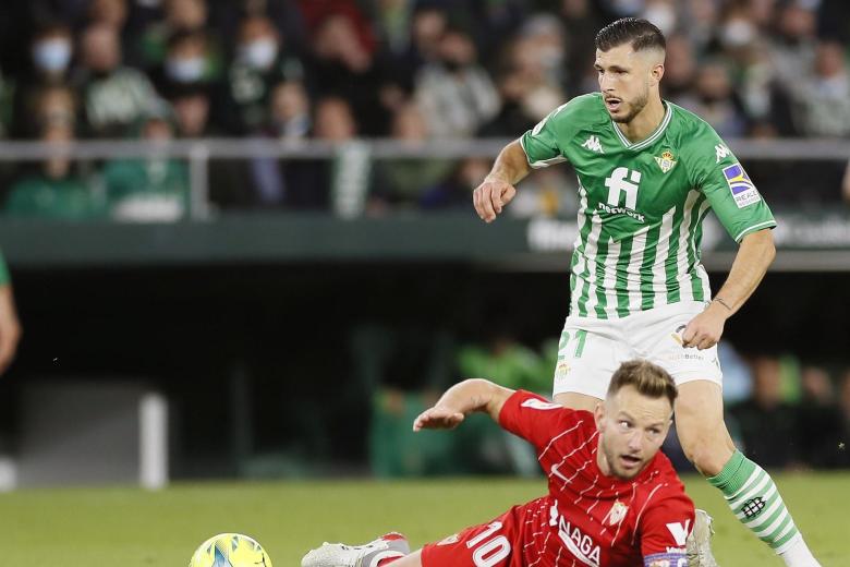 El centrocampista croata del Sevilla, Ivan Rakitic (i), en el suelo ante el centrocampista argentino del Betis, Guido Rodríguez