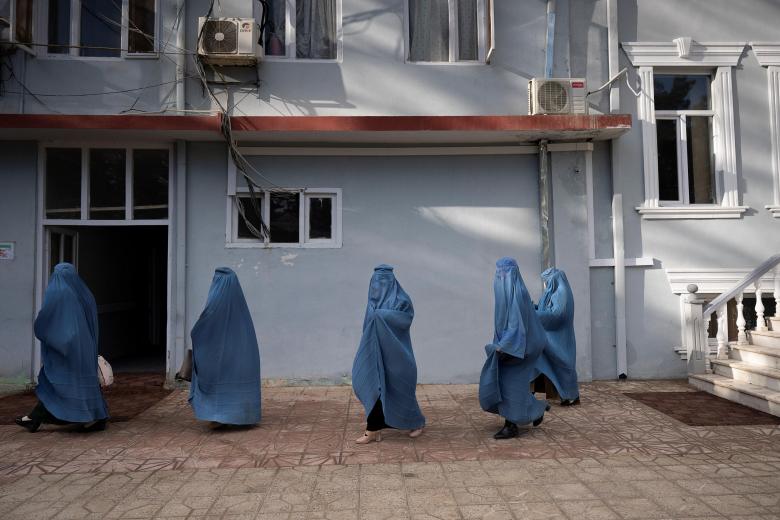Esta foto tomada el 17 de enero de 2022 muestra a empleadas municipales, que han podido seguir trabajando tras la toma del poder por los talibanes, saliendo de su oficina en Maymana, capital de la provincia noroccidental afgana de Faryab. En todo el país, los talibanes han desalojado a las mujeres de la esfera pública, dejando a las niñas mayores fuera de la educación y excluyendo en gran medida a las mujeres del lugar de trabajo. En la oficina del alcalde de Maymana, Damullah Mohibullah Mowaffaq, se ha permitido a las empleadas seguir trabajando, y un jardín público de la ciudad está reservado para ellas.