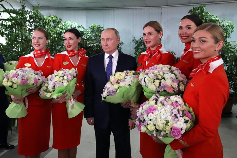 El presidente ruso Vladimir Putin (derecha) posa para fotografías con mujeres de la tripulación de vuelo de las aerolíneas rusas durante su visita al centro de formación de aviación de PJSC Aeroflot en vísperas del Día Internacional de la Mujer en Moscú.