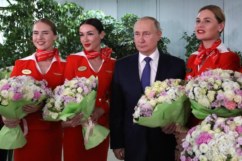 El presidente ruso, Vladimir Putin (2-R), posa para fotografías con mujeres de la tripulación de vuelo de las aerolíneas rusas durante su visita al centro de entrenamiento de aviación de PJSC Aeroflot