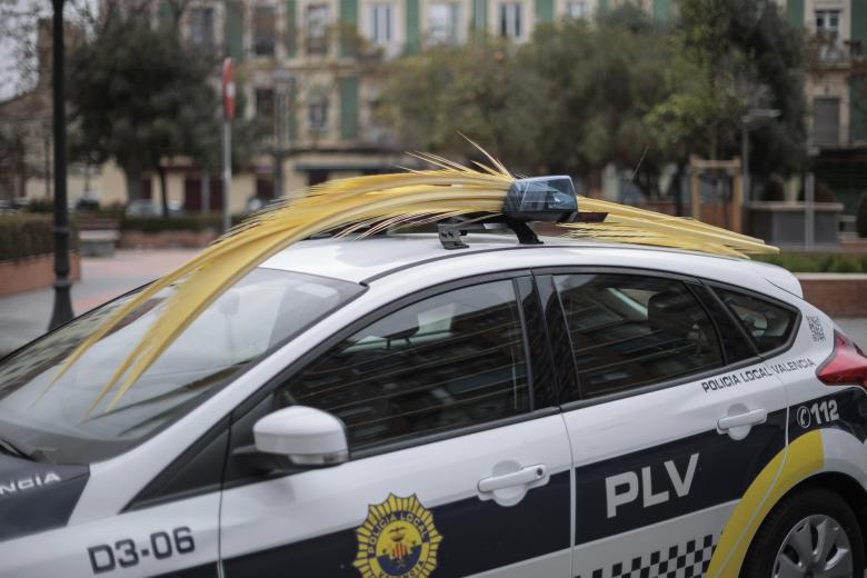 Un vehículo de la Policia Local de Valencia adornado con una palma durante las procesiones del Domingo de Ramos de la Semana Santa de los poblados marítimos de Valencia