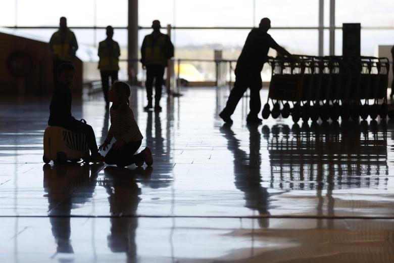 Dos jóvenes viajeras juegan en una de las terminales del Aeropuerto Adolfo Suárez Madrid-Barajas este miércoles
