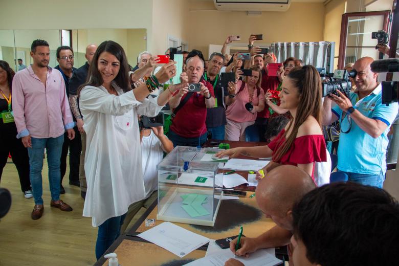 La candidata de Vox a la presidencia de la Junta de Andalucía, Macarena Olona, muestra el sobre con su papeleta momentos antes de introducirlo a la urna