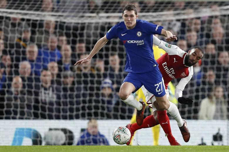 Chelsea's Andreas Christensen, left, escapes Arsenal's Alexandre Lacazette during the English League Cup semifinal, first leg, soccer match between Chelsea and Arsenal at Stamford Bridge stadium in London, Wednesday, Jan. 10, 2018. (AP Photo/Kirsty Wigglesworth)