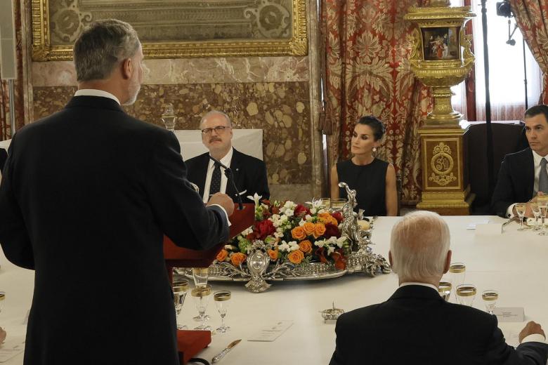 El rey Felipe (i), acompañado por la reina Letizia (2d) y el presidente del Gobierno Pedro Sánchez (d), entre otros, pronuncia unas palabras en el Comedor de Gala del Palacio Real