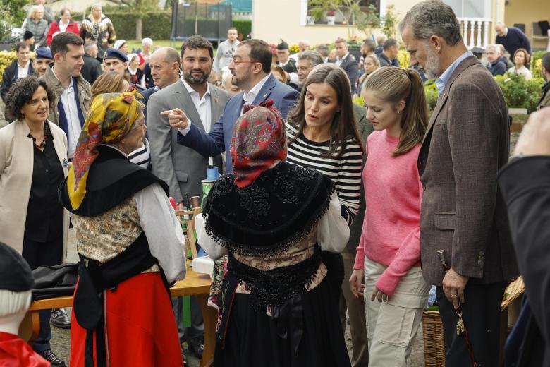 la Familia Real, sin la Infanta Sofía, conversan con dos mujeres de la parroquia de Cadavedo, en el municipio de Valdés