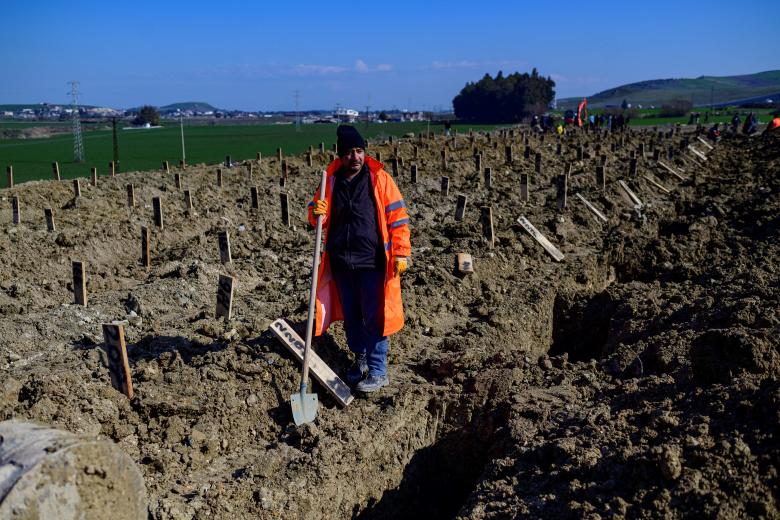 Un empleado de la ciudad cava tumbas en un área de fosas comunes en Hatay