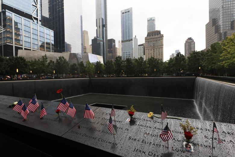 Banderas estadounidense y flores en el memorial a las víctimas del 11-S, ubicado donde se levantaban las Torres Gemelas en Manhattan