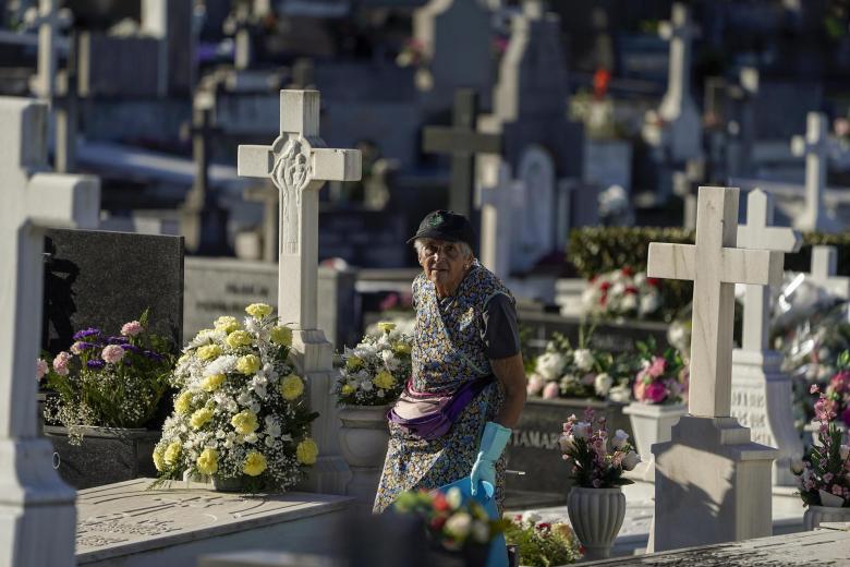 Una persona arregla una tumba en el cementerio de El Salvador de San Esteban de las Cruces, en Oviedo