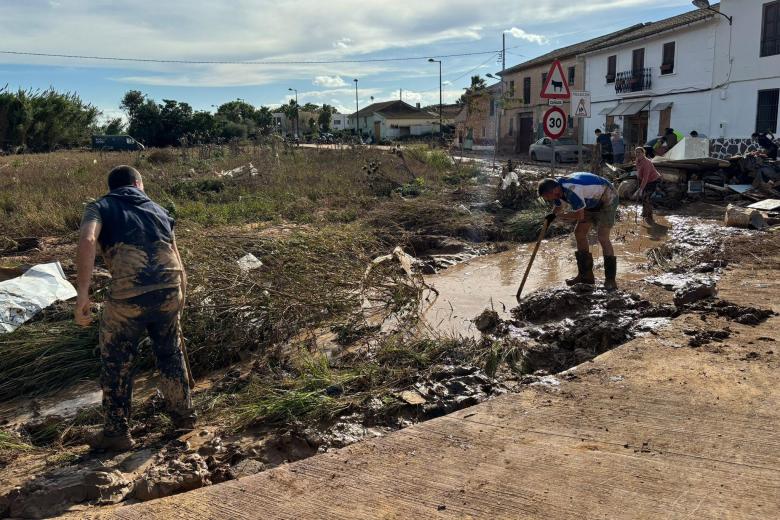 Dos vecinos de la pedanía valenciana de La Torre, sacando barro de las parcelas