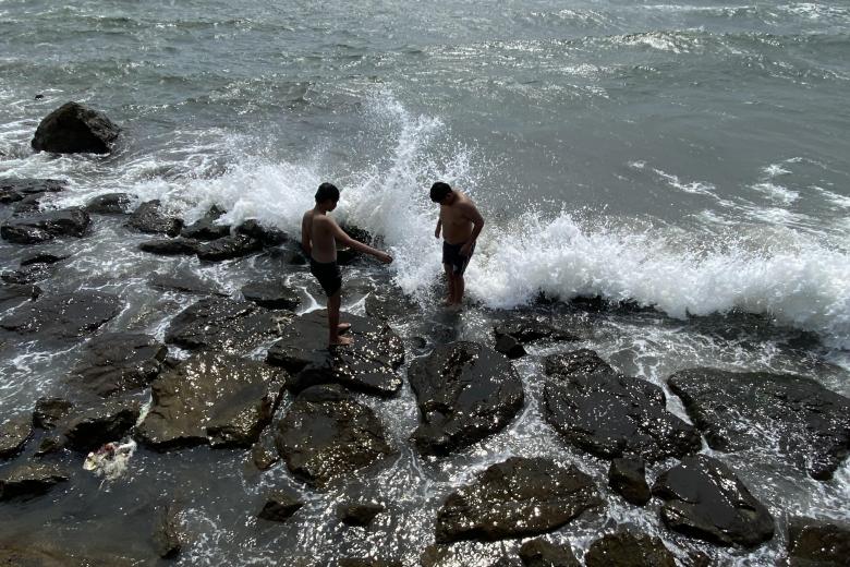 Bañistas retozan a lo largo de una costa en Cavite, Filipinas, 30 de julio de 2025. El Instituto Filipino de Vulcanología y Sismología (Phivolcs) advirtió a las comunidades costeras del país frente al Océano Pacífico sobre posibles olas de tsunami causadas por el terremoto de Rusia