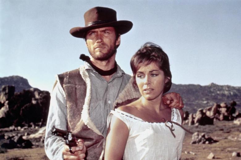 Esta película es la piedra angular que reinventó el cine del oeste, cambiando los héroes tradicionales por un universo mucho más cínico, estético y moralmente ambiguo. La trama inicia con la llegada de un enigmático pistolero sin nombre a San Miguel, un pueblo fronterizo dominado por el miedo y la violencia. Al descubrir que dos poderosas familias rivales, los Baxter y los Rojo, se disputan el control del contrabando local, el extranjero decide utilizar su ingenio y su letal puntería para trabajar para ambos bandos, vendiendo su lealtad al mejor postor. Lo fascinante de la historia es cómo este antihéroe juega un peligroso doble juego, avivando el conflicto en su propio beneficio hasta que la situación estalla de forma inevitable. Sergio Leone sienta aquí las bases de su estilo visual único, con planos innovadores y una tensión que se masca en el ambiente. Apoyada en la magnética presencia de Clint Eastwood y la inolvidable música de Ennio Morricone, la obra se convierte en un ejercicio magistral de suspense, estrategia y pura acción.