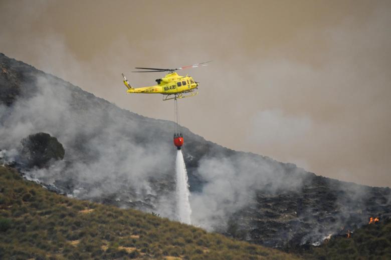Un helicóptero del servicio de extinción de incendios arroja agua sobre uno de los focos del incendio forestal declarado en Los Gallardos, el más grave ocurrido en España hasta la fecha, dado el balance provisional de fallecidos, 12 confirmados a esta hora