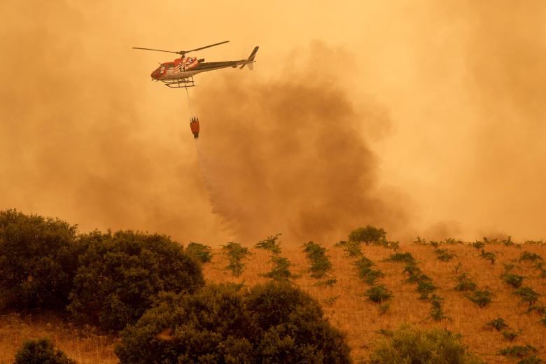Un helicóptero lanza agua para intentar apagar el incendio de Ávila