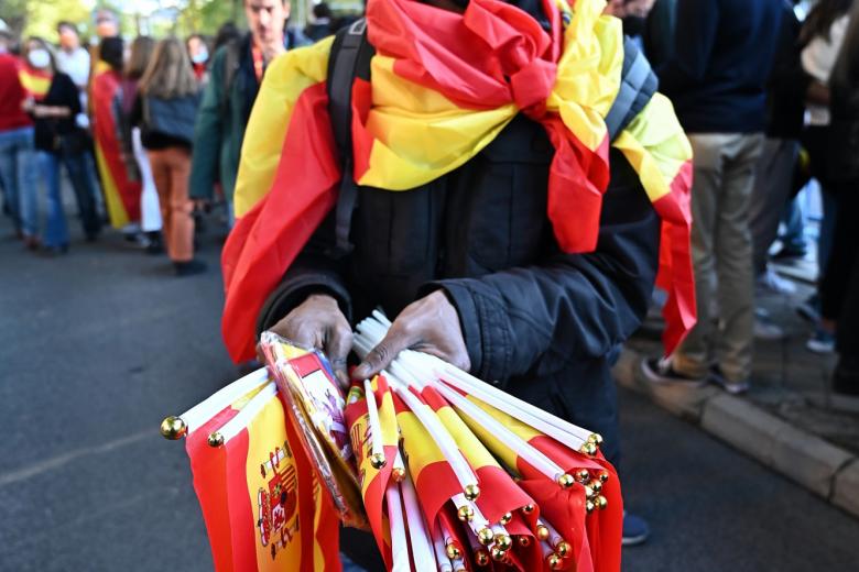 Un hombre vende banderas de España en el Paseo de la Castellana