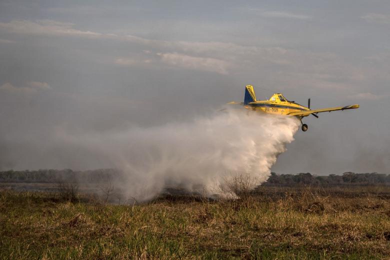 Un avión descarga agua sobre un incendio en Porto Jofre, Mato Grosso.