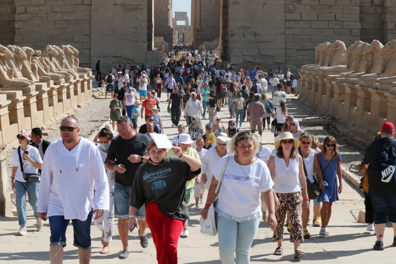 Turistas que atraviesan la Avenida de las Esfinges que conecta el complejo religioso de Karnak con el templo de Luxor