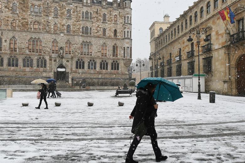 Una mujer pasea por la capital leonesa cubierta de nieve