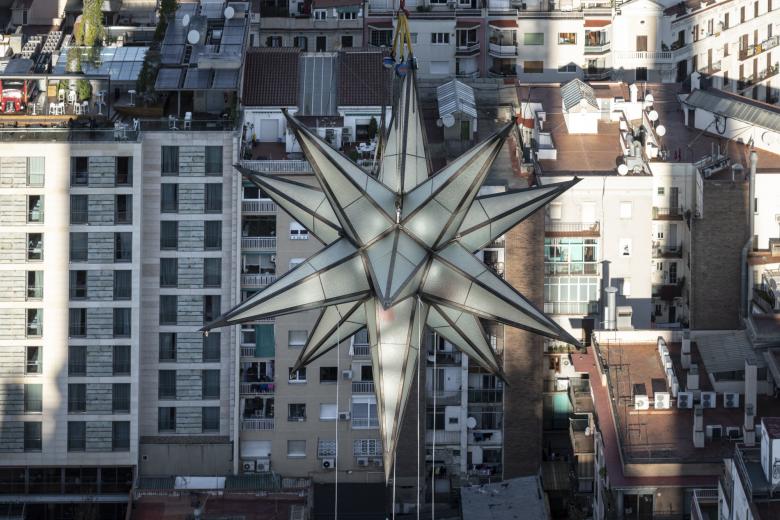 La estrella luminosa de la Sagrada Familia de Barcelona levantada por una grúa