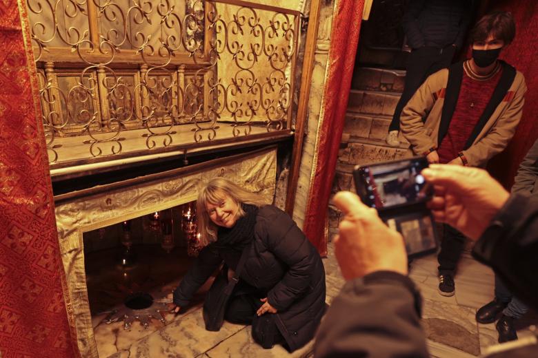 Una turista visita el lugar donde tradicionalmente se cree que nació Jesús, debajo de la Iglesia de la Natividad en Belén