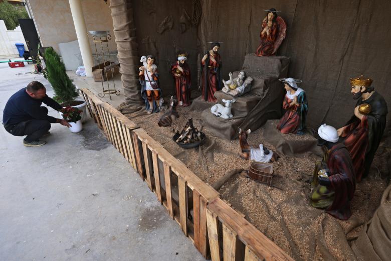 Un hombre decora con motivos navideños la iglesia de San José en Bagdad, capital de Irak