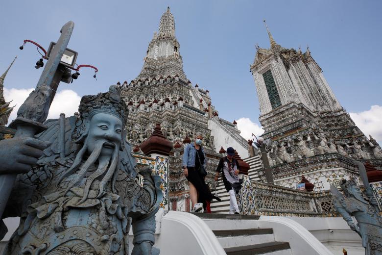 Un grupo de turistas visita el templo de Wat Arun, también conocido como el templo del amanecer, durante el programa para personas vacunados del coronavirus, en Bangkok, Tailandia este martes