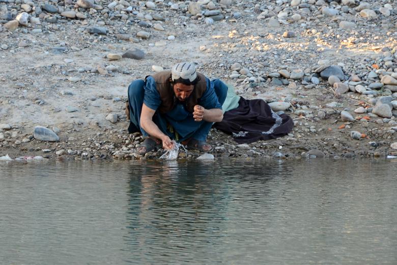 Un hombre realiza la ablución en un río antes de ofrecer su oración en Arghandab, en la parte central de la provincia de Kandahar