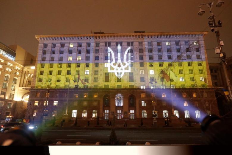 El edificio del ayuntamiento de iev iluminado con los colores de la bandera nacional ucraniana se ve en Kiev, Ucrania