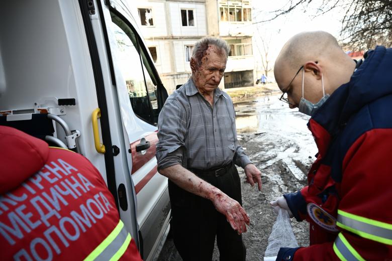 El personal de la unidad de emergencia trata a un hombre herido después de los bombardeos en la ciudad de Chuguiv, en el este de Ucrania.