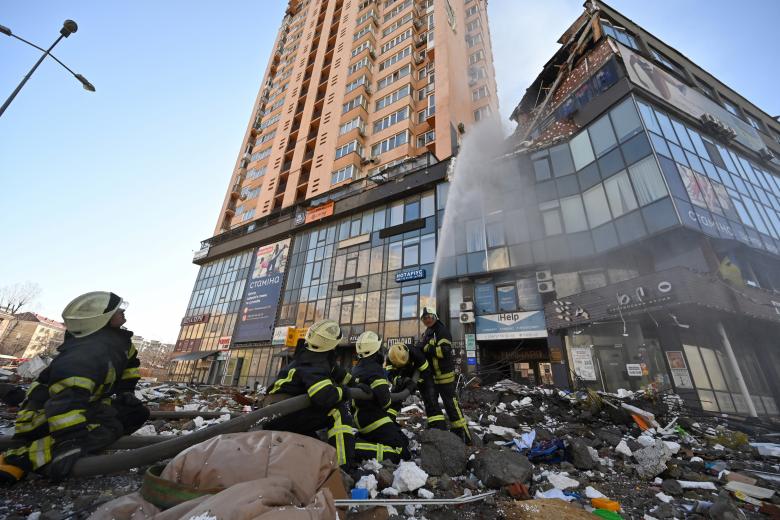 Los bomberos extinguen el fuego en un bloque de apartamentos de gran altura que fue alcanzado por un bombardeo reciente en Kiev.