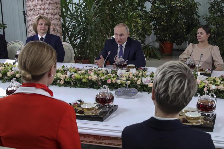 El presidente ruso, Vladimir Putin (centro), se reúne con mujeres de la tripulación de vuelo de las aerolíneas rusas durante su visita al centro de formación de aviación de PJSC Aeroflot en vísperas del Día Internacional de la Mujer en Moscú