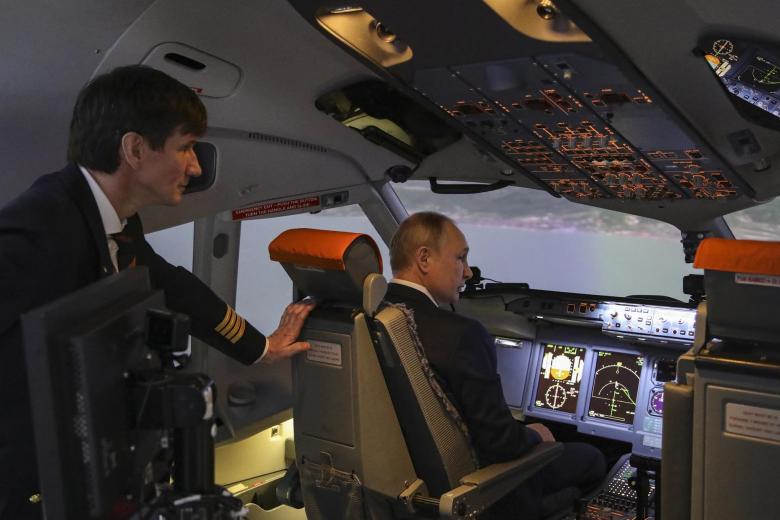 El presidente ruso Vladimir Putin (R) examina los simuladores para la tripulación de vuelo durante su visita al centro de entrenamiento de aviación de PJSC Aeroflot.