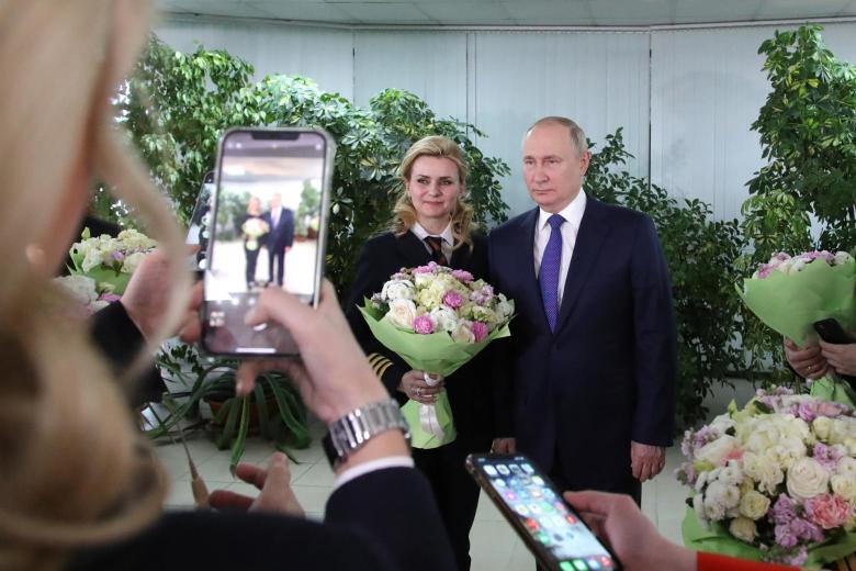 El presidente ruso, Vladimir Putin (derecha), posa para fotografías con mujeres de la tripulación de vuelo de las aerolíneas rusas durante su visita al centro de entrenamiento de aviación