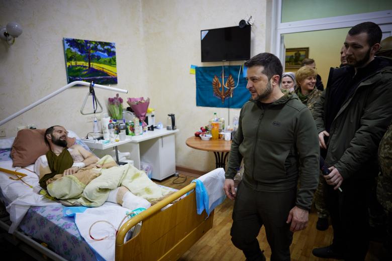 In this handout picture released and taken by Ukrainian Presidency Press Office on March 13, 2022, Ukrainian President Volodymyr Zelensky shakes hands with an injured man during a visit at a military hospital following fightings in the Kyiv region. - According to the presidency official website, Zelensky made a visit to the hospital to "award militaries with orders and medals for courage and dedication, and to honor the hospital staff for exemplary work in difficult conditions". (Photo by Handout / UKRAINIAN PRESIDENTIAL PRESS SERVICE / AFP) / RESTRICTED TO EDITORIAL USE - MANDATORY CREDIT "AFP PHOTO / UKRAINIAN PRESIDENTIAL PRESS SERVICE " - NO MARKETING - NO ADVERTISING CAMPAIGNS - DISTRIBUTED AS A SERVICE TO CLIENTS - RESTRICTED TO EDITORIAL USE - MANDATORY CREDIT "AFP PHOTO / Ukrainian presidential press service " - NO MARKETING - NO ADVERTISING CAMPAIGNS - DISTRIBUTED AS A SERVICE TO CLIENTS /