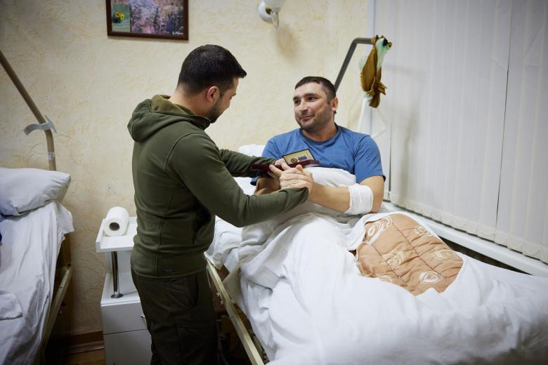 In this handout picture released and taken by Ukrainian Presidency Press Office on March 13, 2022, a member of the medical staff receives is awarded by Ukrainian President Volodymyr Zelensky (R) during his visit at a military hospital following fightings in the Kyiv region. - According to the presidency official website, Zelensky made a visit to the hospital to "award militaries with orders and medals for courage and dedication, and to honor the hospital staff for exemplary work in difficult conditions". (Photo by Handout / UKRAINIAN PRESIDENTIAL PRESS SERVICE / AFP) / RESTRICTED TO EDITORIAL USE - MANDATORY CREDIT "AFP PHOTO / UKRAINIAN PRESIDENTIAL PRESS SERVICE " - NO MARKETING - NO ADVERTISING CAMPAIGNS - DISTRIBUTED AS A SERVICE TO CLIENTS - RESTRICTED TO EDITORIAL USE - MANDATORY CREDIT "AFP PHOTO / Ukrainian presidential press service " - NO MARKETING - NO ADVERTISING CAMPAIGNS - DISTRIBUTED AS A SERVICE TO CLIENTS /