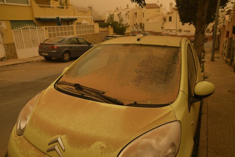 Un vehículo cubierto de polvo en Aguadulce, Roquetas de Mar (Almería) que ha amanecido este martes bajo los efectos de la intensa calima que ha cubierto de polvo sahariano buena parte de España
