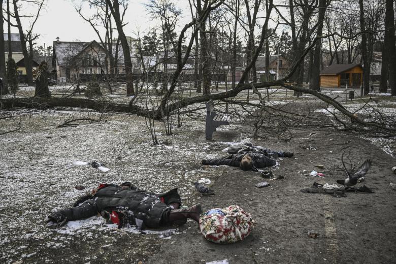 EDITORS NOTE: Graphic content / Bodies of civilians lie in a park in Irpin, north of Kyiv, on March 10, 2022. - Russian forces on March 10, 2022 rolled their armoured vehicles up to the northeastern edge of Kyiv, edging closer in their attempts to encircle the Ukrainian capital. Kyiv's northwest suburbs such as Irpin and Bucha have been enduring shellfire and bombardments for more than a week, prompting a mass evacuation effort. (Photo by Aris Messinis / AFP)