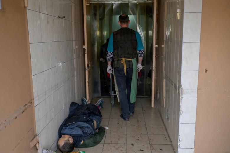 EDITORS NOTE: Graphic content / A body lies on the ground in the corridor of a morgue in  Mykolaiv, a city on the shores of the Black Sea that has been under Russian attack for days on March 11, 2022. - Mykolaiv and its region have seen heavy fighting, but the Ukrainians are resisting and retook the local airport a few days ago. As the last major town before the great port city of Odessa, it is a vital strategic position. (Photo by BULENT KILIC / AFP) / The metadata of this photo by BULENT KILIC has been modified in AFP systems. Please immediately remove the erroneous mention[s] from all your online services and delete it (them) from your servers. If you have been authorized by AFP to distribute it (them) to third parties, please ensure that the same actions are carried out by them. Failure to promptly comply with these instructions will entail liability on your part for any continued or post notification usage. Therefore we thank you very much for all your attention and prompt action. We are sorry for the inconvenience this notification may cause and remain at your disposal for any further information you may require.