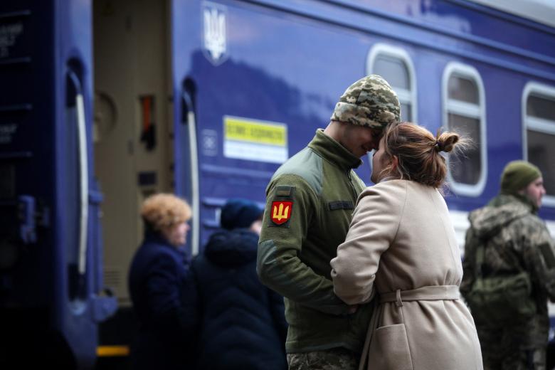A Ukrainian serviceman says goodbye to his girlfriend before departing in the direction of Kyiv at the central train station in the western Ukrainian city of Lviv on March 9, 2022, amid the ongoing Russia's invasion of Ukraine. (Photo by Aleksey Filippov / AFP)